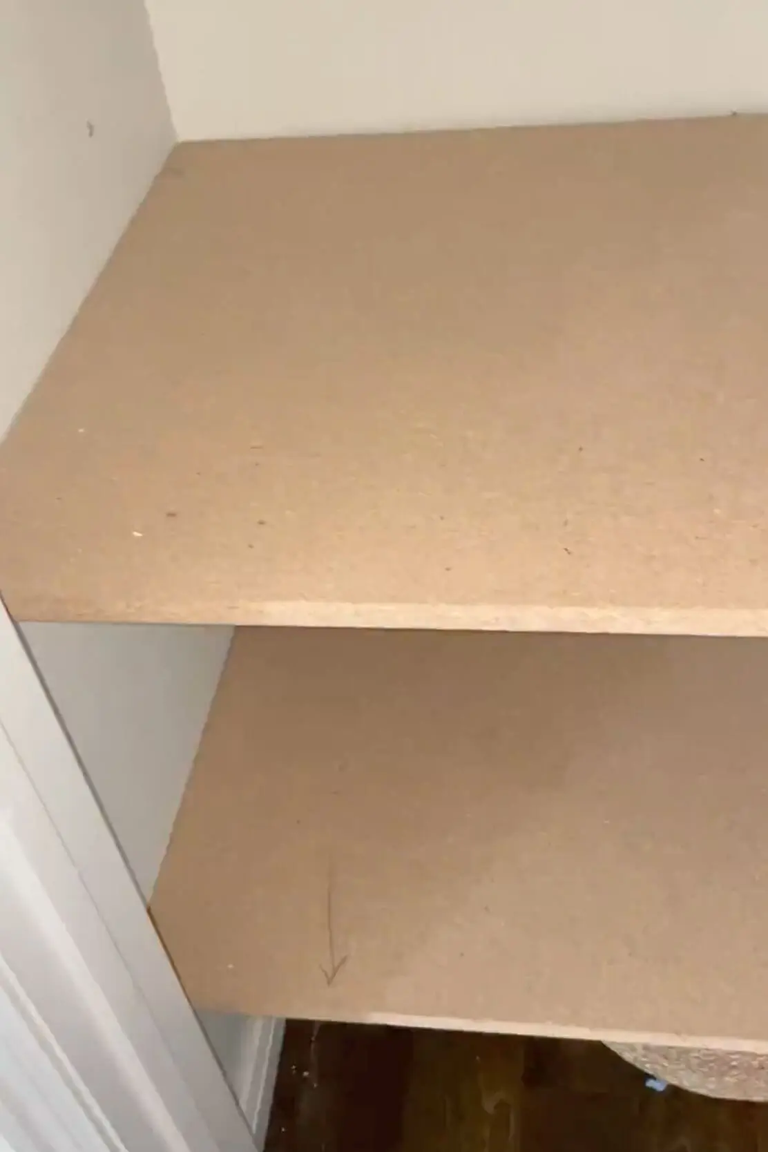 Freshly installed MDF shelves inside a small closet, adding extra storage space for a DIY home organization project.